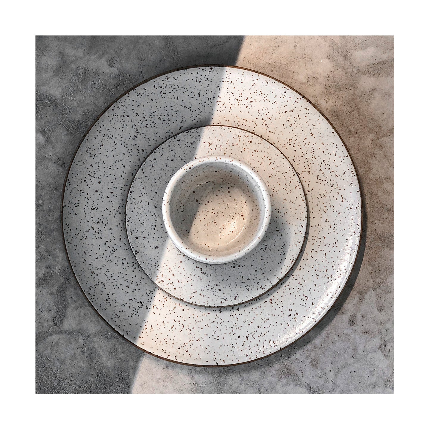 vista superior de xícara de café e pires sobre prato de sobremesa em cerâmica artesanal com esmalte branco